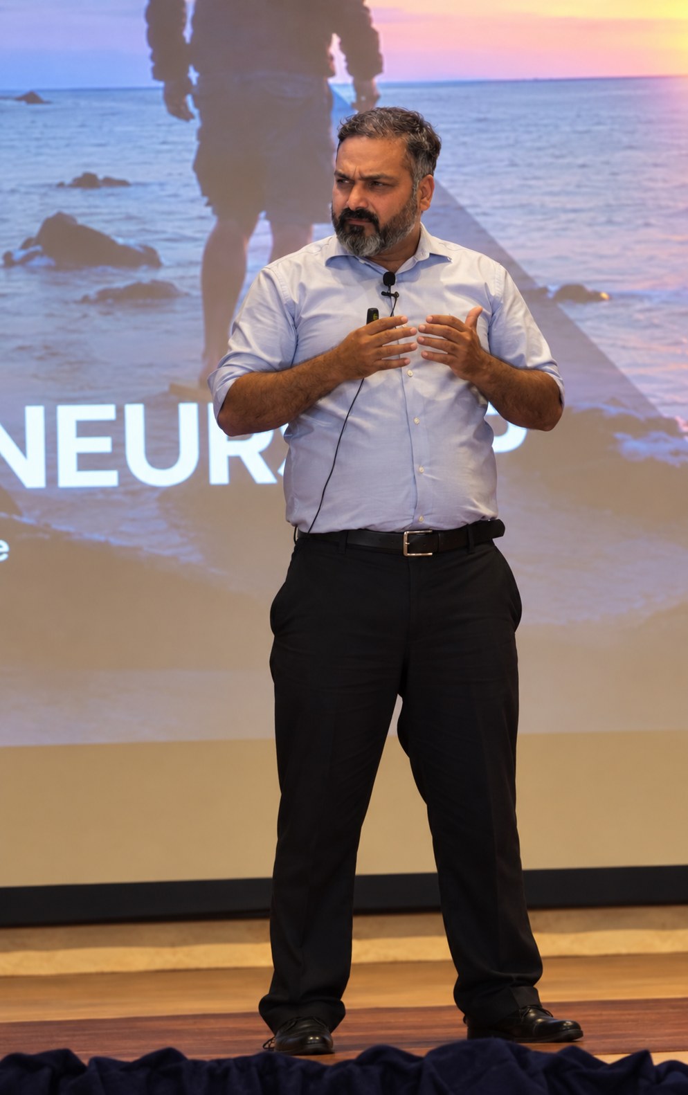Syed Muzaffar Tirmizi speaking on stage